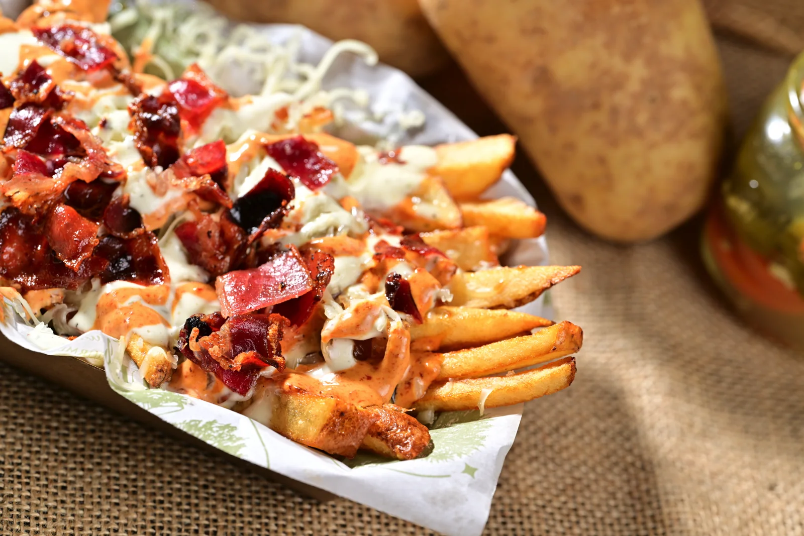 Papas bravas con queso, tocino y aderezo